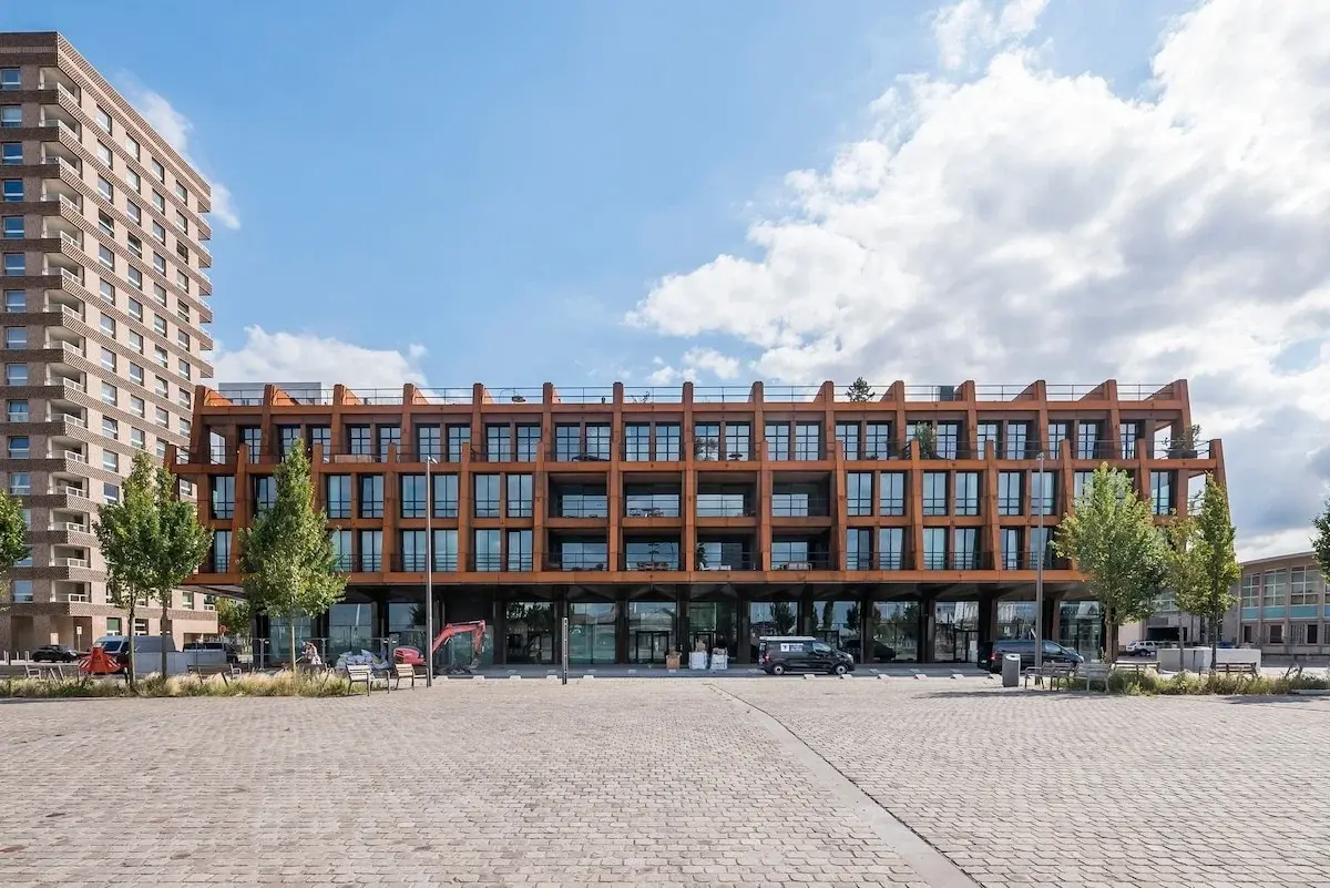 Edificio moderno con facciata in acciaio color ruggine su una piazza lastricata